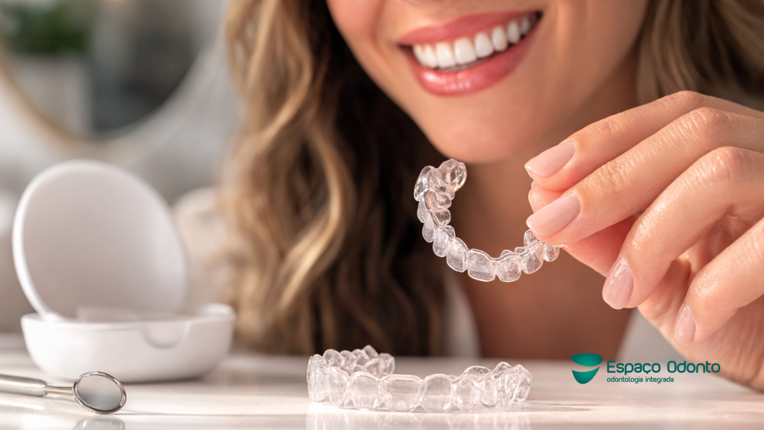 Paciente segurando alinhador transparente removível durante tratamento ortodôntico